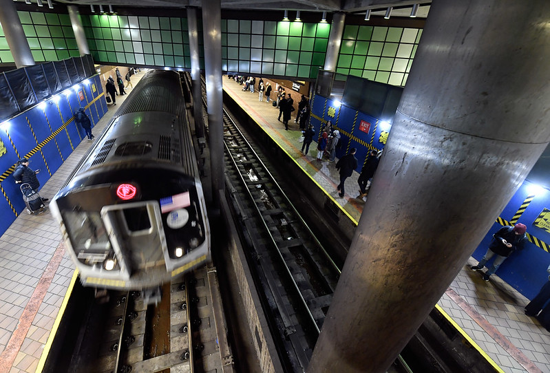 F train running through Queens subway station