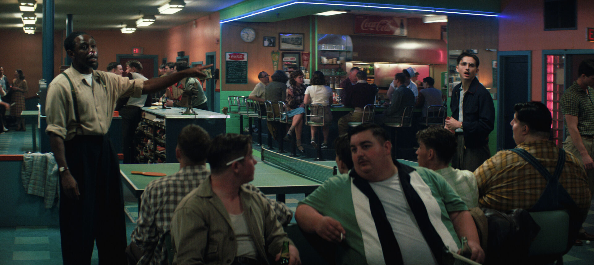 Tyler Okonma (left) and Timothée Chalamet (right) play table tennis at a bowling alley.