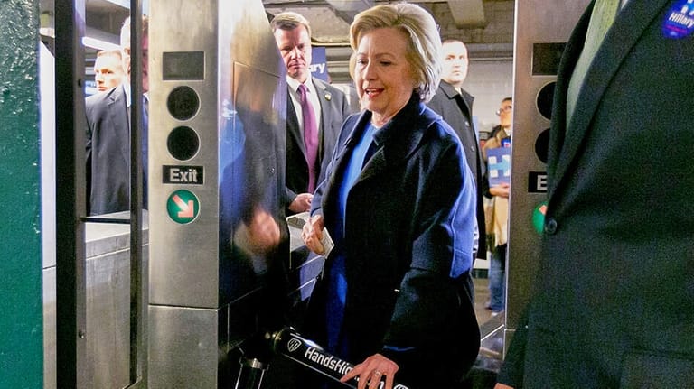 Democrat presidential candidate Hillary Clinton holds her MetroCard as she...
