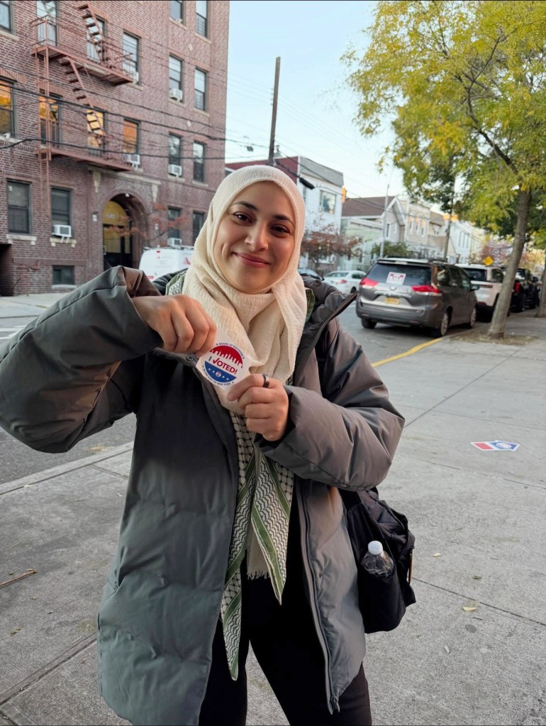 Aber Kawas holding an "I Voted!" sticker.
