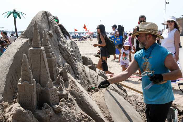 man working at sand sculpting contest
