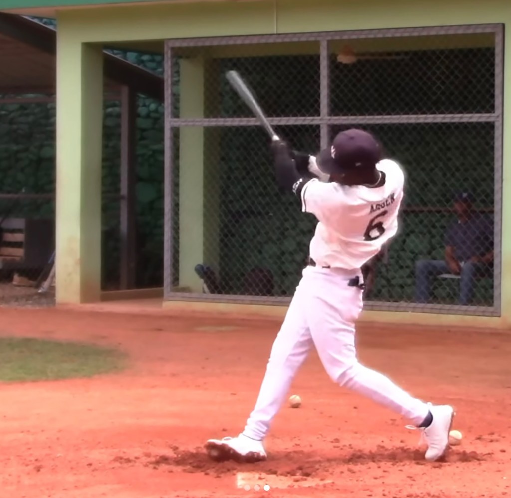 Baseball player Wandy Asigen hitting a baseball.