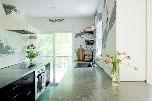 The kitchen features polished concrete countertops and black reeded custom cabinetry.