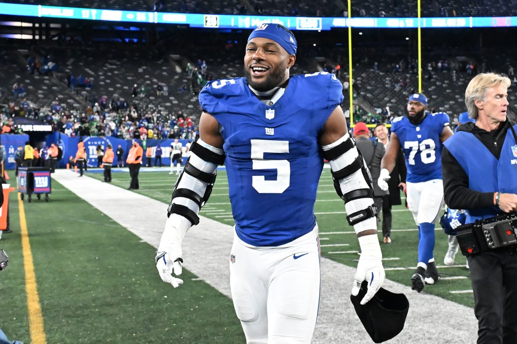 Giants linebacker Kayvon Thibodeaux (5) smiles while walking off the field.