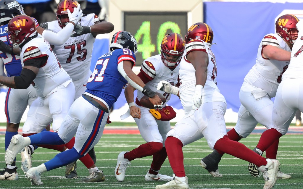 Linebacker Abdul Carter #51 of the New York Giants sacks quarterback Marcus Mariota #8 of the Washington Commanders.