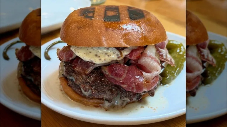 The grass-fed beef burger at Rolo's in NYC with chargrilled marks on bun
