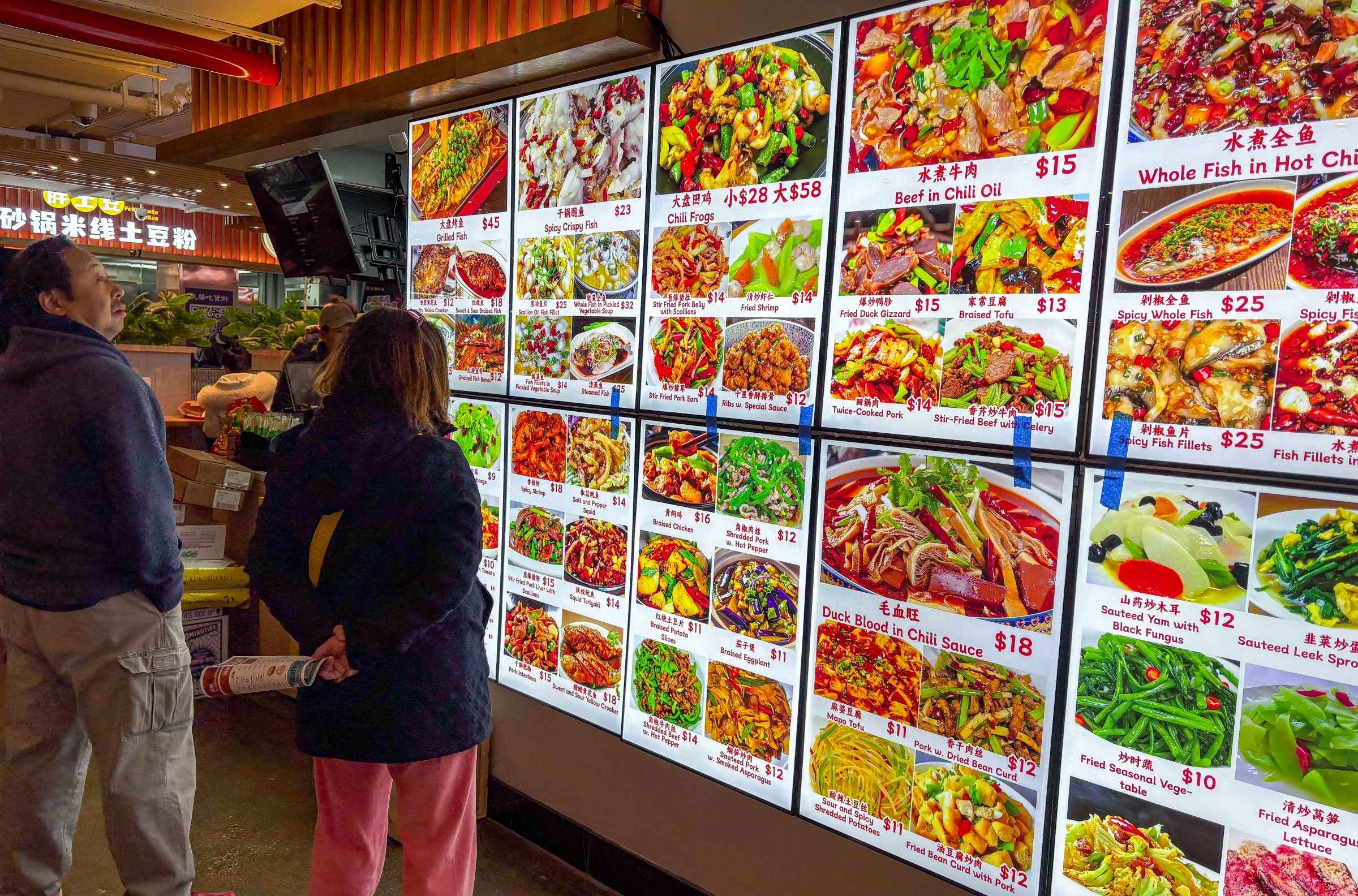 A lit-up menu display with images of foods.