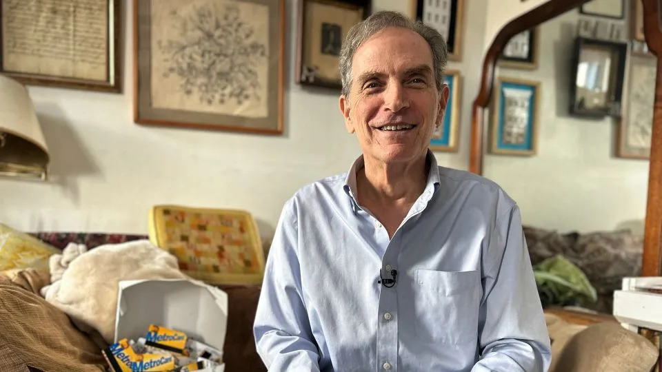 New York City artist Thomas McKean, who creates sculptures and mosaics with MetroCards, cuts a MetroCard on January 27, 2023. - Roselle Chen/Reuters