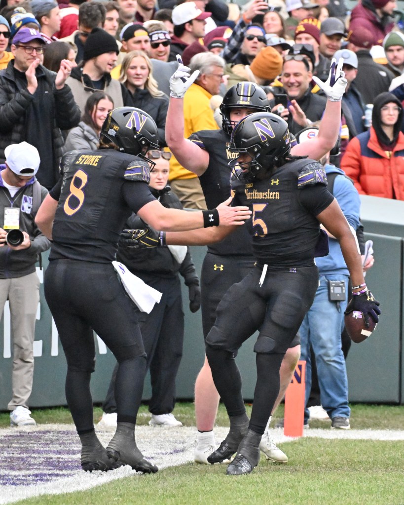 Northwestern Wildcats tight end Lawson Albright (86), running back Caleb Komolafe (5) and quarterback Preston Stone (8) celebrate a touchdown against the Minnesota Golden Gophers during the second half at Wrigley Field.