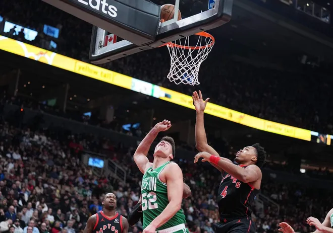Dec 20, 2025; Toronto, Ontario, CAN; Boston Celtics center Luka Garza (52) drives to the basket as Toronto Raptors forward Scottie Barnes (4) tries to defend during the first quarter at Scotiabank Arena.