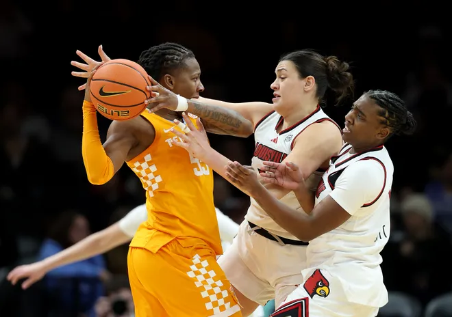 Talaysia Cooper #55 of the Tennessee Lady Volunteers looks to pass as Elif Istanbulluoglu #11 and Reyna Scott #1 of the Louisville Cardinals defend during the 2025 Women's Champions Classic at Barclays Center on December 20, 2025 in the Brooklyn borough of New York City.