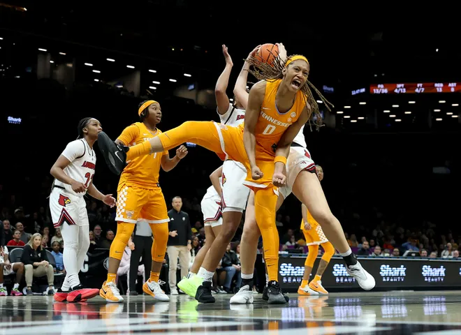 Janiah Barker #0 of the Tennessee Lady Volunteers reacts as Laura Ziegler #0 and Mackenly Randolph #4 of the Louisville Cardinals fight for the ball during the 2025 Women's Champions Classic at Barclays Center on December 20, 2025 in the Brooklyn borough of New York City.