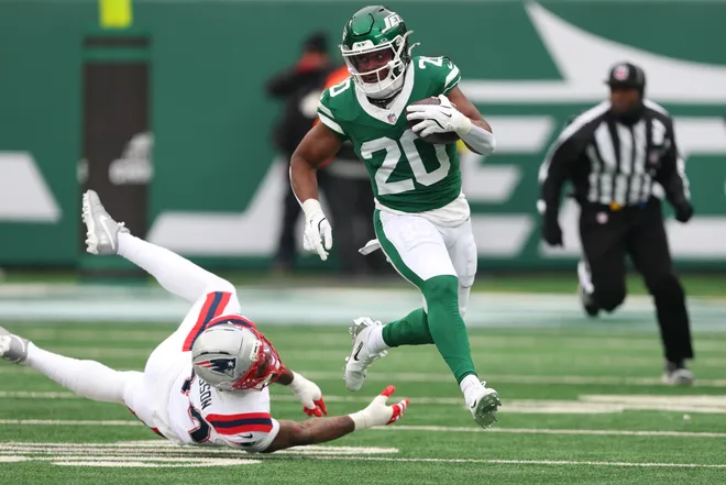 Dec 28, 2025; East Rutherford, New Jersey, USA; New York Jets running back Breece Hall (20) runs the ball against New England Patriots linebacker K'Lavon Chaisson (44) during the second quarter of the game at MetLife Stadium. Mandatory Credit: Vincent Carchietta-Imagn Images