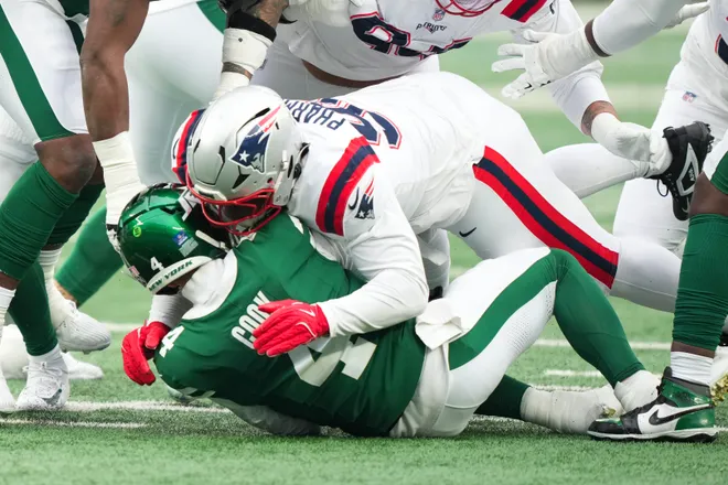 Dec 28, 2025; East Rutherford, New Jersey, USA; New England Patriots defensive tackle Jeremiah Pharms Jr. (98) sacks New York Jets quarterback Brady Cook (4) but is penalized for roughing the passer during the second half of the game at MetLife Stadium. Mandatory Credit: Robert Deutsch-Imagn Images