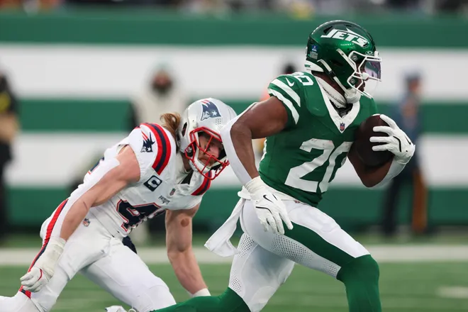Dec 28, 2025; East Rutherford, New Jersey, USA; New York Jets running back Breece Hall (20) runs for a touchdown against New England Patriots safety Brenden Schooler (41) during the second half of the game at MetLife Stadium. Mandatory Credit: Vincent Carchietta-Imagn Images