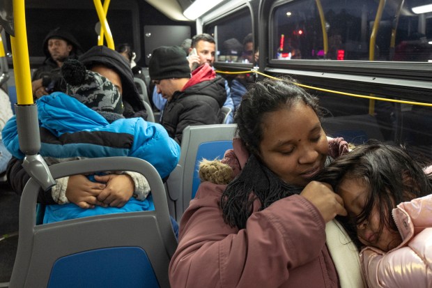 Ecuadorian Leidy Andrade rides a bus with her daughter as they return to a shelter in the Jamaica neighborhood of the Queens borough of New York, Tuesday, Jan. 14, 2025, after picking up her daughter from a school in Brooklyn. Andrade and her family were recently relocated to a migrant shelter in Queens after the family shelter at Floyd Bennett Field was closed. (AP Photo/Klaus Galiano)