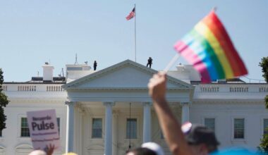 A protestor holds up a pride flag as marchers demonstrate in front of The White House.