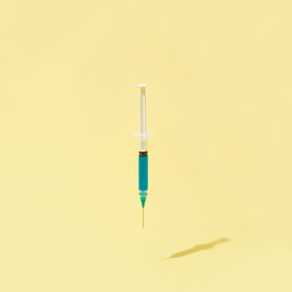A floating syringe on a yellow background