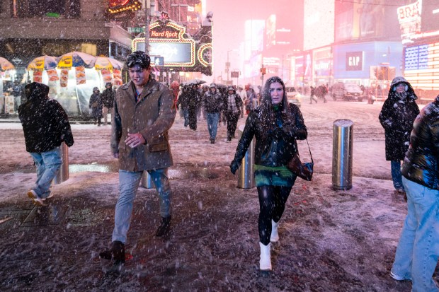 People walking through Times Square during a snow storm at night on February 08, 2025 in New York City. (Photo by Craig T Fruchtman/Getty Images)