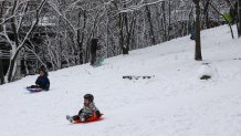 Children sled in a park in the Brooklyn borough of New York City on December 27, 2025. New York City receieved around 4 inches (10 centimeters) of snow overnight. Airlines canceled 1,500 US flights during the peak holiday travel period Friday, with severe winter storm warnings and heavy snow forecast across parts of the Midwest and northeast. (Photo by ANGELA WEISS / AFP via Getty Images)