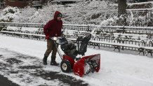 A worker clears a path of snow in New York City on December 27, 2025. New York City receieved around 4 inches (10 centimeters) of snow overnight. Airlines canceled 1,500 US flights during the peak holiday travel period Friday, with severe winter storm warnings and heavy snow forecast across parts of the Midwest and northeast. (Photo by ANGELA WEISS / AFP via Getty Images)