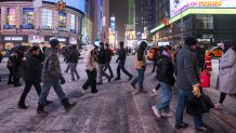 People walking through Times Square during a snow storm at night on December 26, 2025 in New York City. (Photo by Craig T Fruchtman/Getty Images)