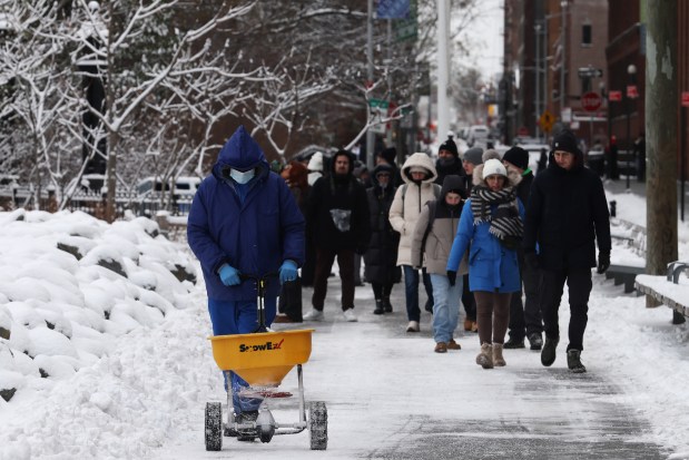 People walk through the snow in Brooklyn after an overnight storm on December 27, 2025 in New York City. The New York City metro area received over 4 inches of snow, the first time the city had recorded over 4 inches since a winter storm in January 2022. (Photo by Spencer Platt/Getty Images)