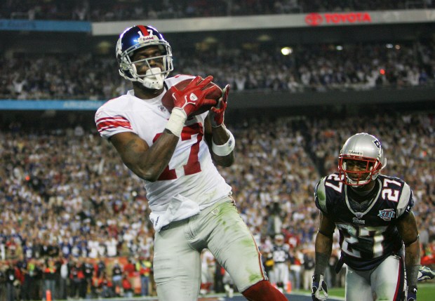GLENDALE, AZ - FEBRUARY 03: Wide receiver Plaxico Burress #17 of the New York Giants catches a 13-yard touchdown pass in the fourth quarter over Ellis Hobbs #27 of the New England Patriots during Super Bowl XLII on February 3, 2008 at the University of Phoenix Stadium in Glendale, Arizona. (Photo by Streeter Lecka/Getty Images)