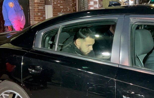 Justin Aguilera, 19, is pictured in police custody leaving the NYPD's 109th Precinct stationhouse in Queens on Dec. 4, 2025. (Kerry Burke / New York Daily News)