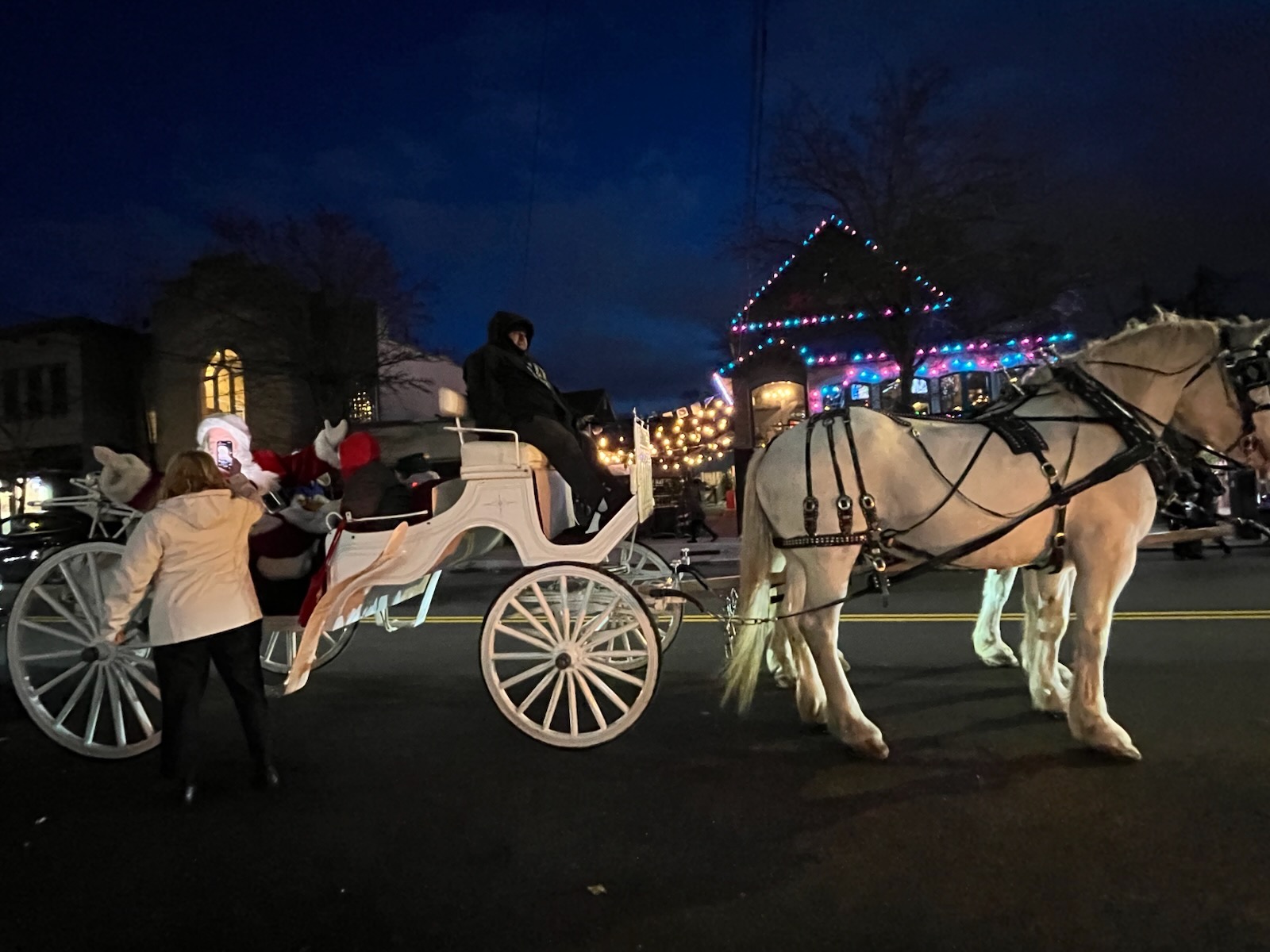 Local businesses offered festive treats along Forest Avenue as Santa arrived in a horse-drawn carriage for the community celebration.