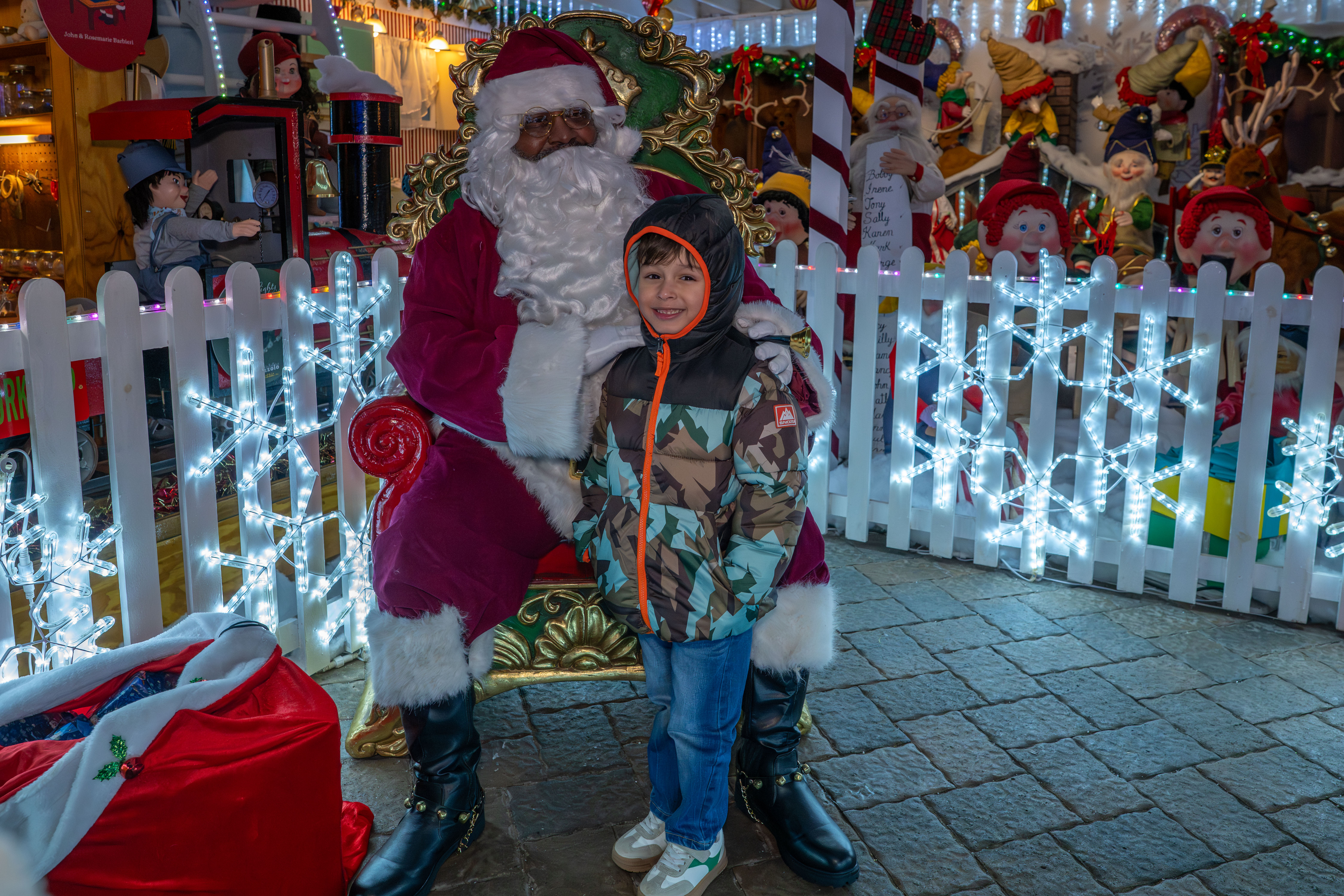 Matthew Reyes, 4, grandson of Taisha Figueroa, a Northwell Staten Island University Hospital employee who is being honored with a Day of Surprises, meets Santa Claus at the DeMartino Christmas House in Charleston on Tuesday, December 16, 2025. (Owen Reiter for the Advance/SILive.com)
