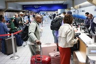 Dewayne Handy, 55, waits with his luggage by his wife as they check in ahead of his flight...
