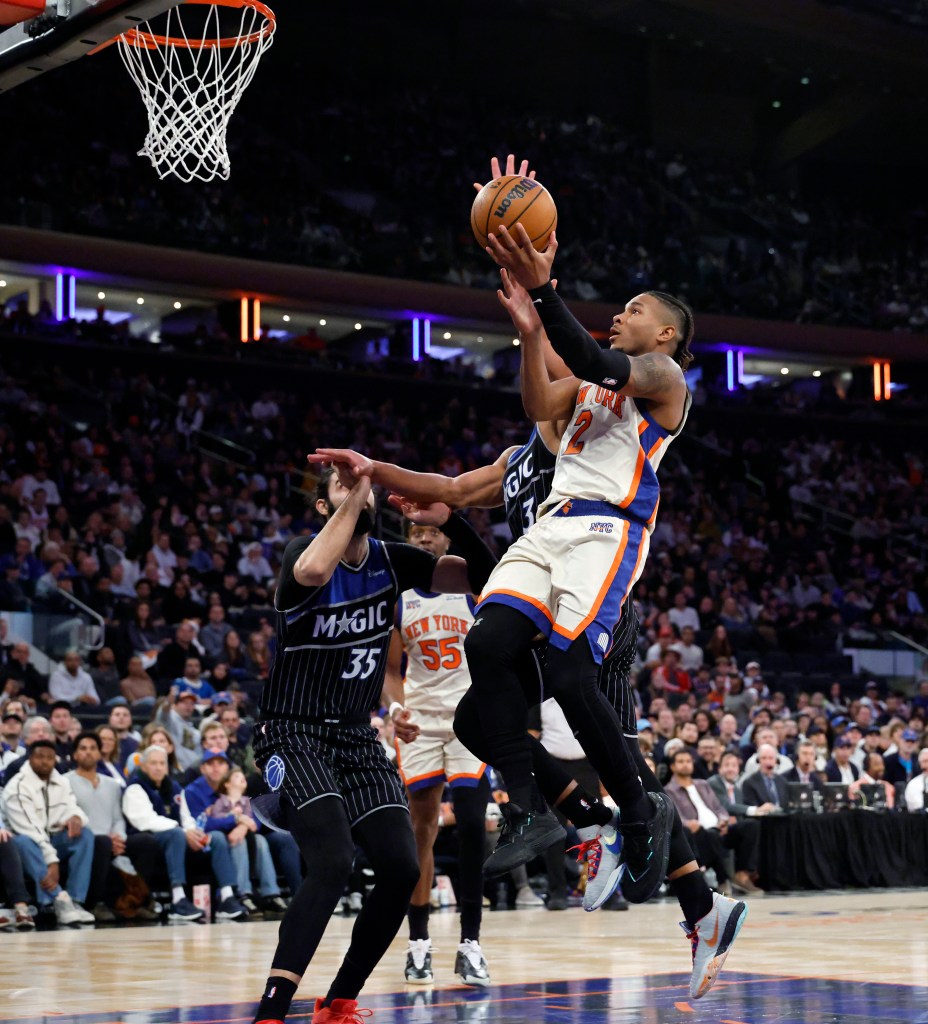 New York Knicks guard Miles McBride (R) puts up a shot past Orlando Magic center Goga Bitadze (L) in the second half at Madison Square Garden in New York, Sunday, December 07, 2025. 