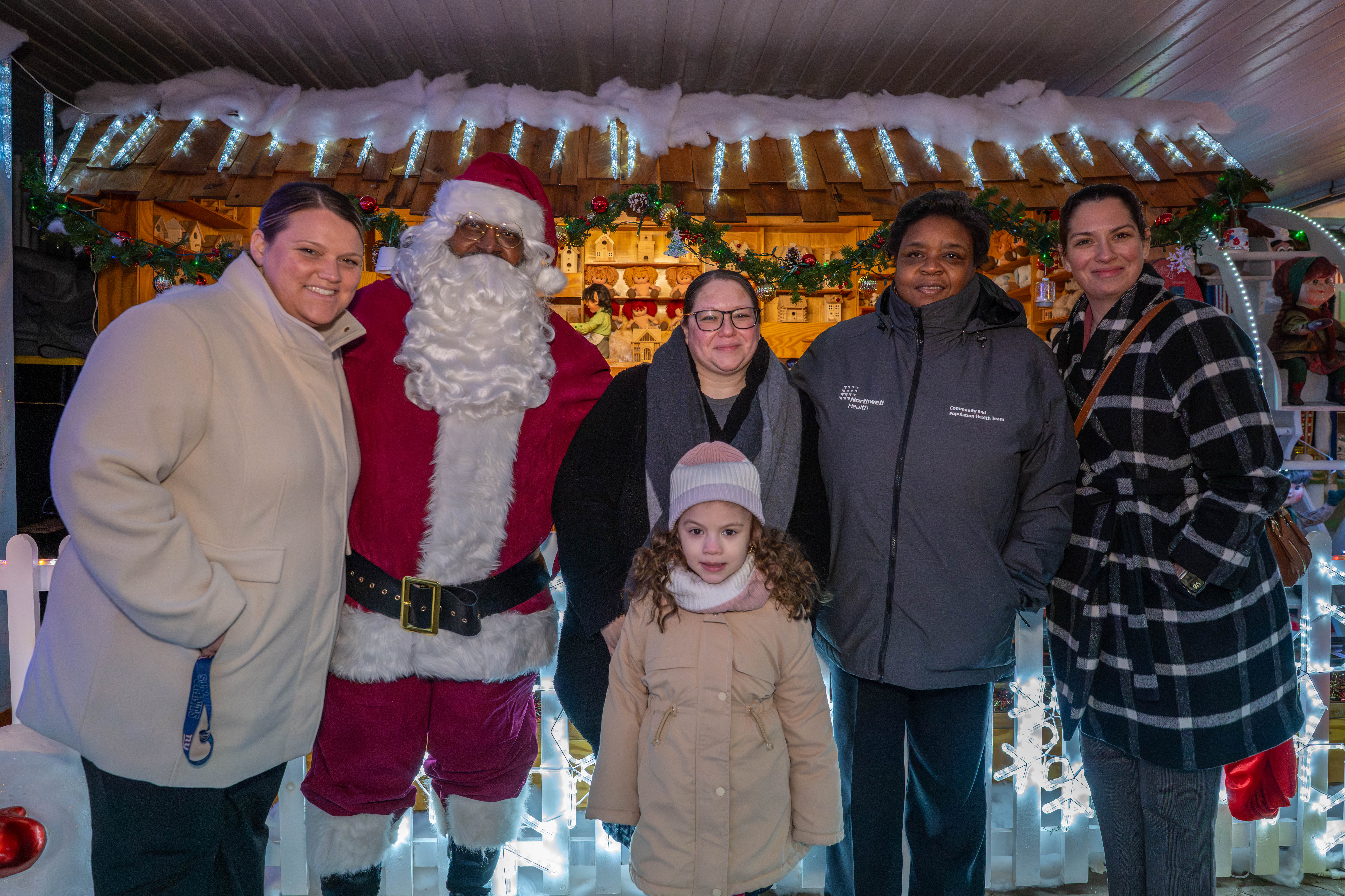 From the left, Kelly Manganaro, Santa Claus, Taisha Figueroa, Julissa Irizarry, 6, Claudette Hill, and Meagan Sills, president of Northwell’s Staten Island University Hospital at the DeMartino Christmas House in Charleston on Tuesday, December 16, 2025. Figueroa, a Northwell Staten Island University Hospital employee, is being honored with a Day of Surprises. (Owen Reiter for the Advance/SILive.com)