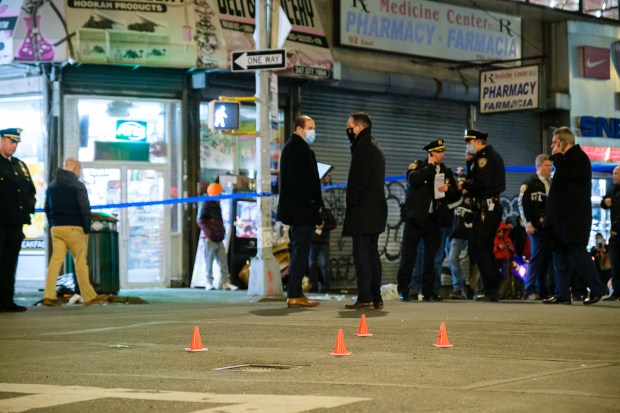 NYPD officers mark bullet shell casings on the pavement with small orange cones as they investigate a police involved shooting on East 167th St. and Walton Ave. on Feb. 16, 2021.