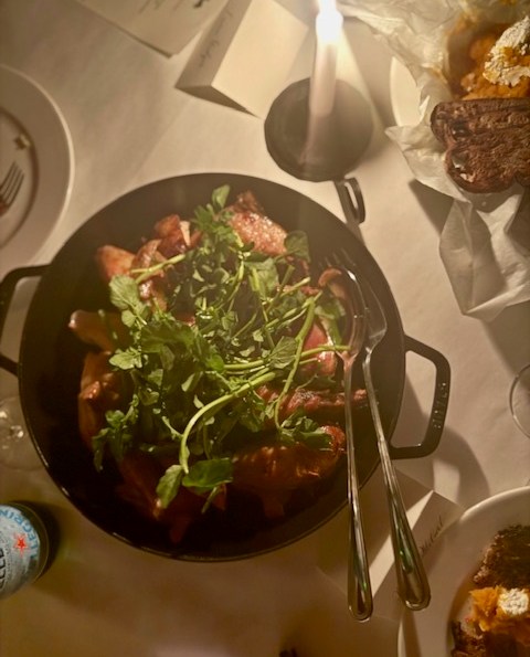 A cast-iron pan of chicken and herbs.