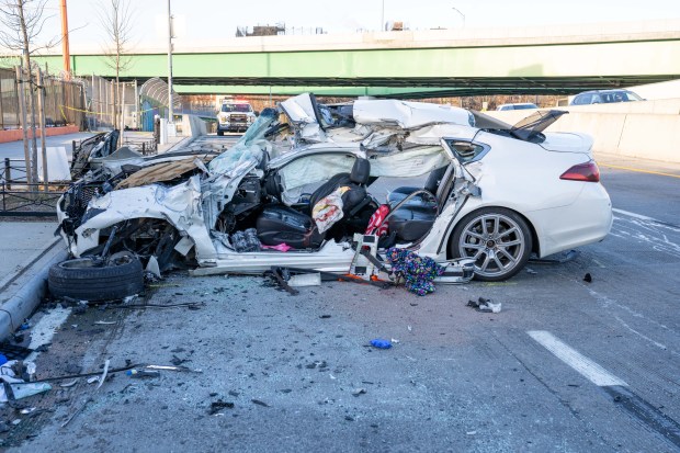 A woman was killed and her two passengers hospitalized after her white Infiniti sedan crashed into a tractor-trailer and a box truck on Bruckner Blvd. near Sheridan Blvd. in the Bronx early Friday, Dec. 5, 2025. (Theodore Parisienne / New York Daily News)