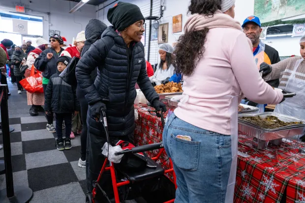 Rev. Al Sharpton, along with Gwen Carr and elected officials including John Liu and Gale Brewer, serve food to a large and appreciative crowd at the National Action Network Headquarters on W. 145th St. in Manhattan on Thursday, Dec. 25, 2025. (Theodore Parisienne / New York Daily News)
