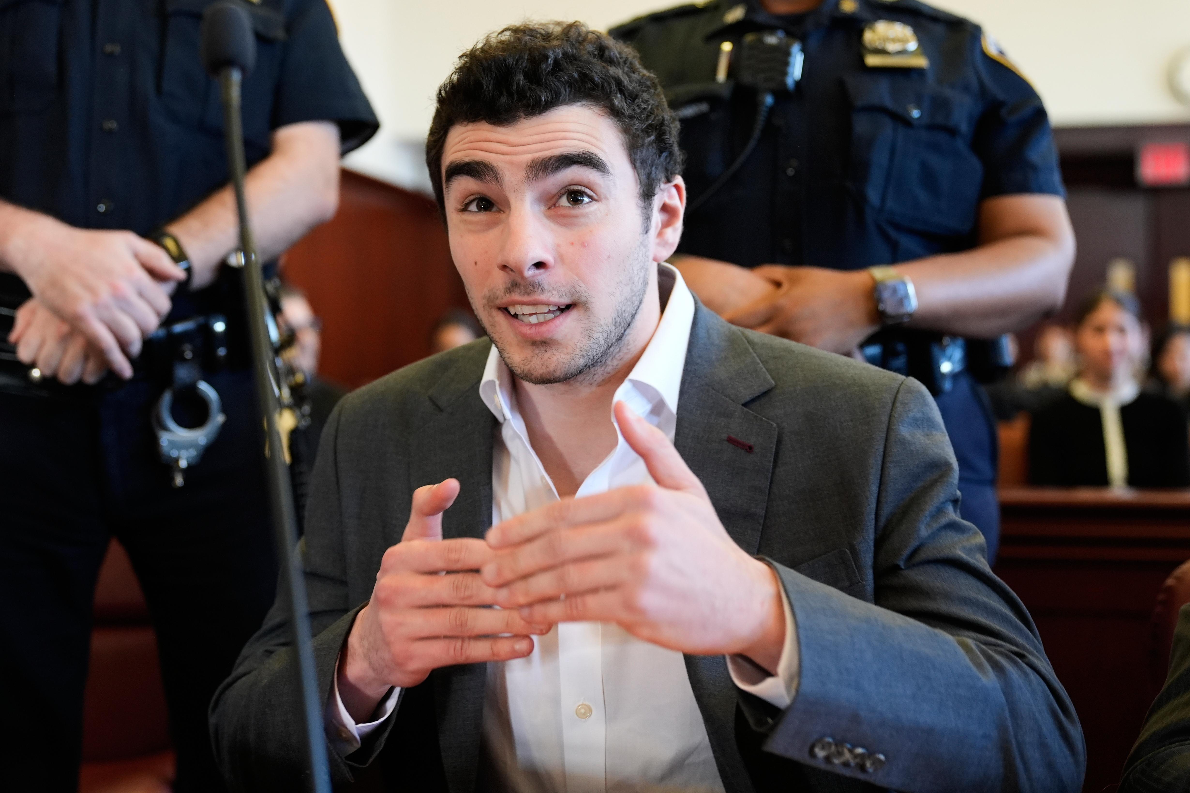 Luigi Mangione talks to a photographer as he appears in...