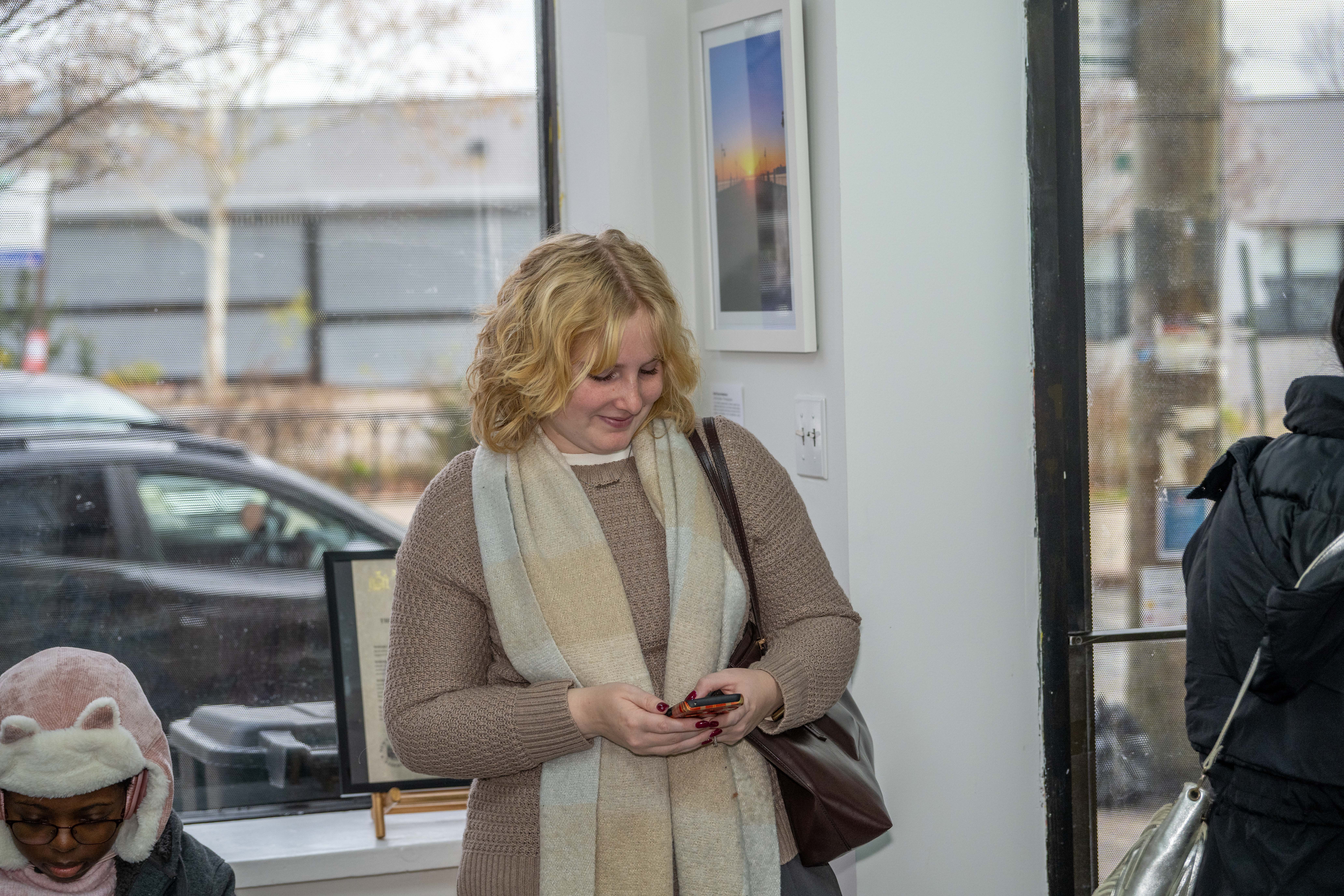 Lexy Cordato, from Snug Harbor Cultural Center & Botanical Garden, attends the grand opening of the Staten Island Urban Center’s new storefront at 206 Bay Street in Tompkinsville on Saturday, December 6, 2025. (Owen Reiter for the Advance/SILive.com)