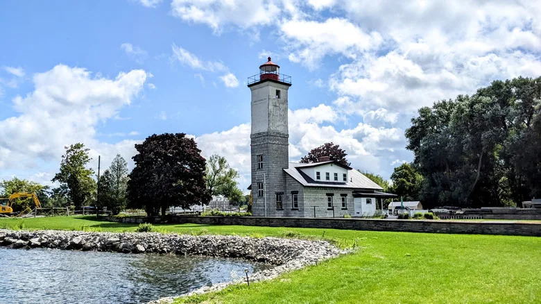 The Ogdensburg Harbor Lighthouse with grassy lawn and water