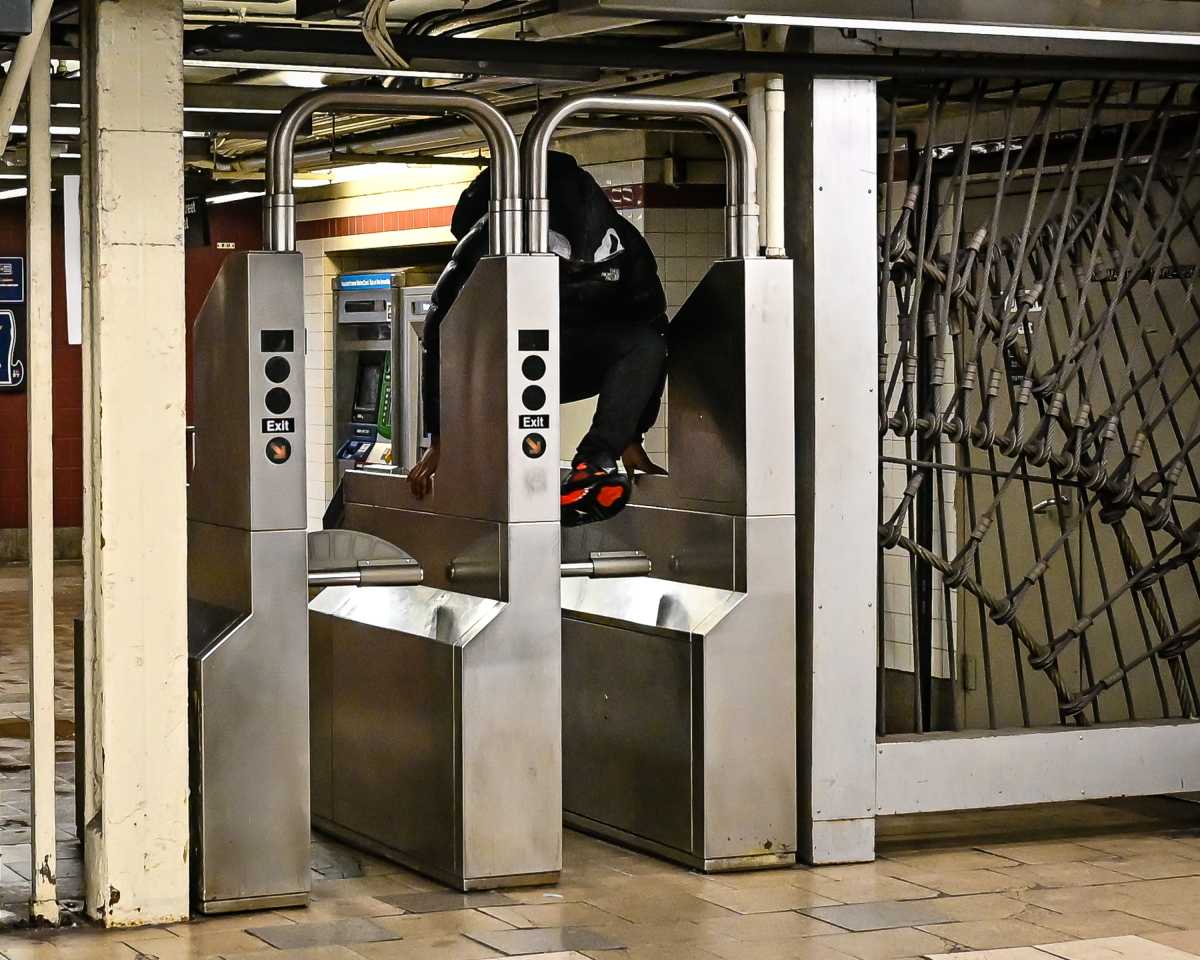 person evading a fare at subway station where the MTA installed metal barriers