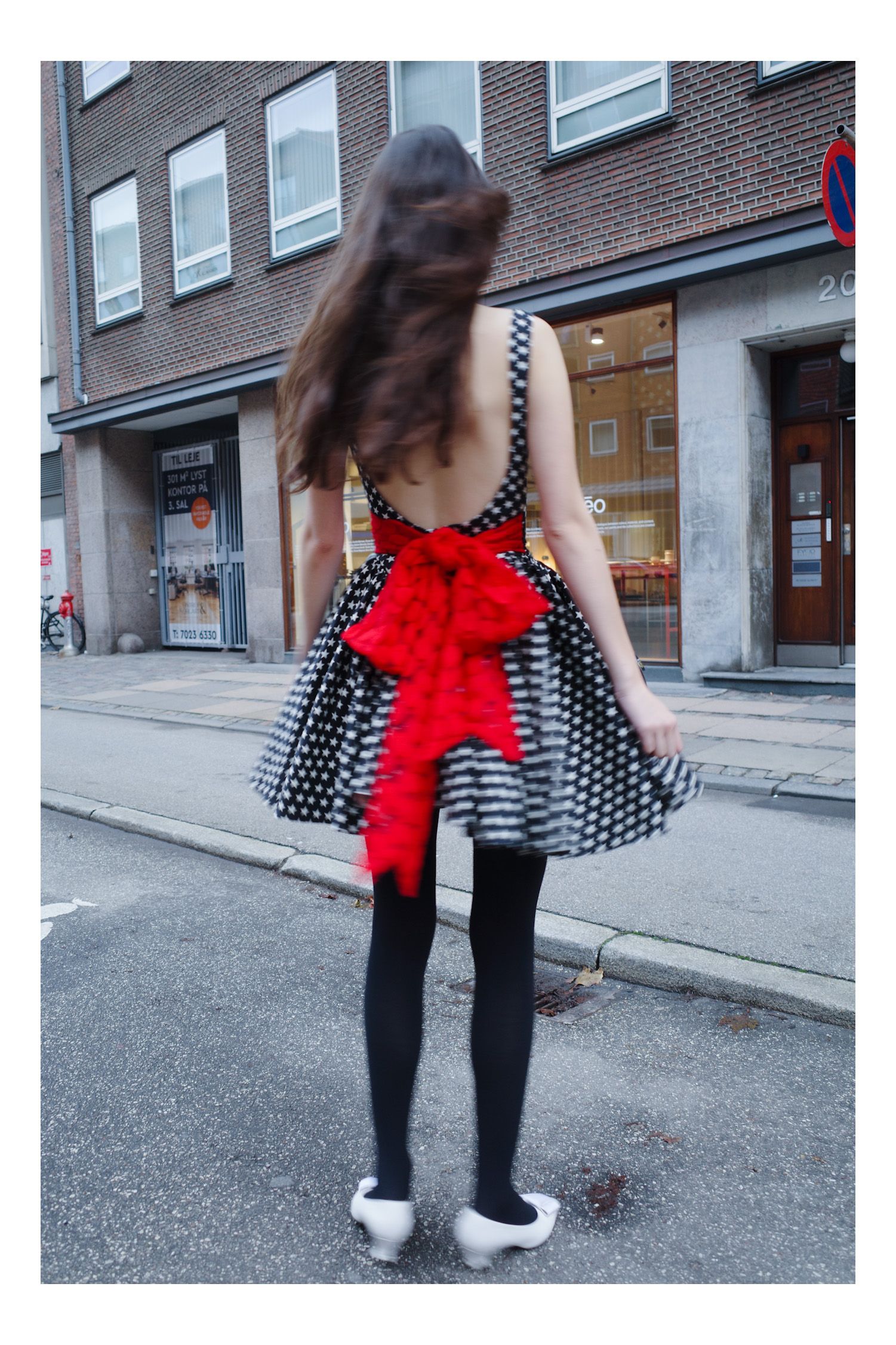 Image may contain City Road Street Urban Clothing Dress Person Teen Bicycle Transportation Vehicle and Coat