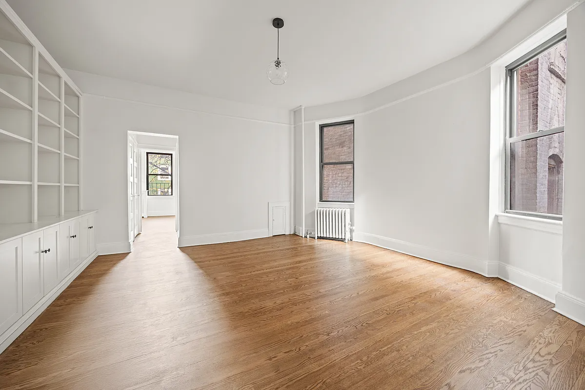 living room with built-in bookshelves, wood floors, white walls