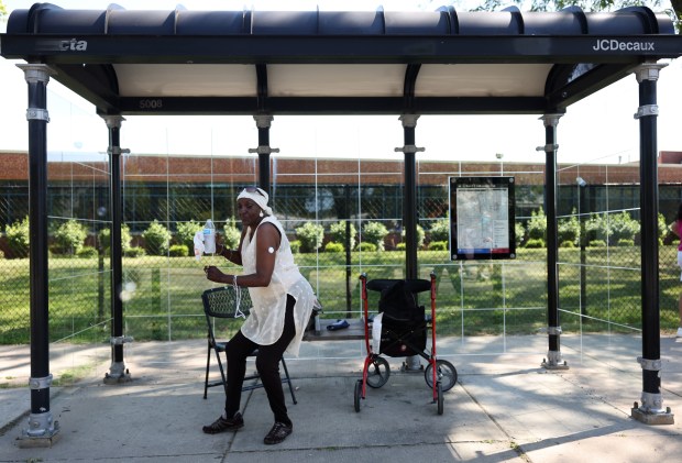 Vivian Loving dances under the shade of a Robert A.M. Stern bus shelter while viewing the Chicago Labor Day parade along South Cottage Grove Avenue in the Pullman neighborhood Sept. 2, 2023. (John J. Kim/Chicago Tribune)