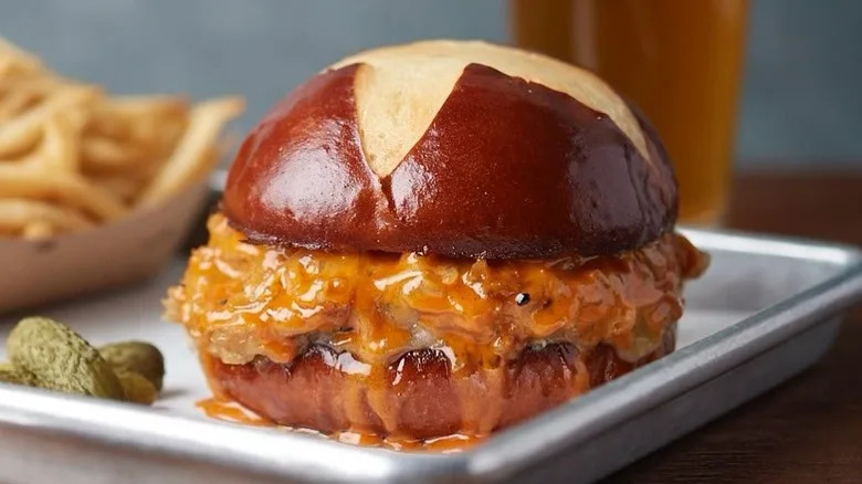 The Emmy Burger served on a tray with french fries, cornichons, and a pint of beer