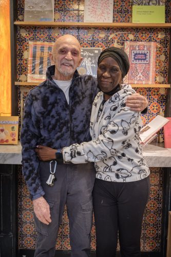 Bernd and Yvonne stand with their arms around each other, smiling at the camera.