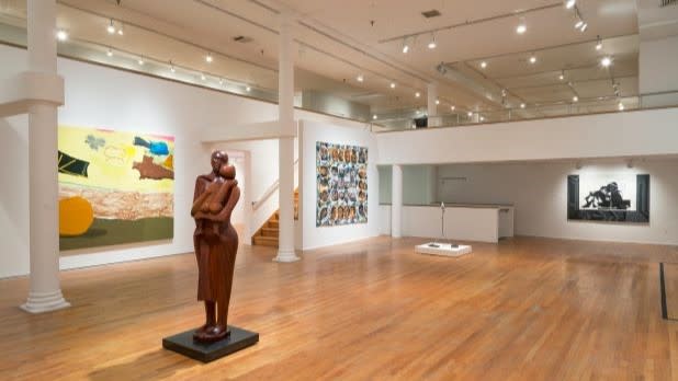 A statue sits in the center of a bright exhibit space at the Studio Museum in Harlem