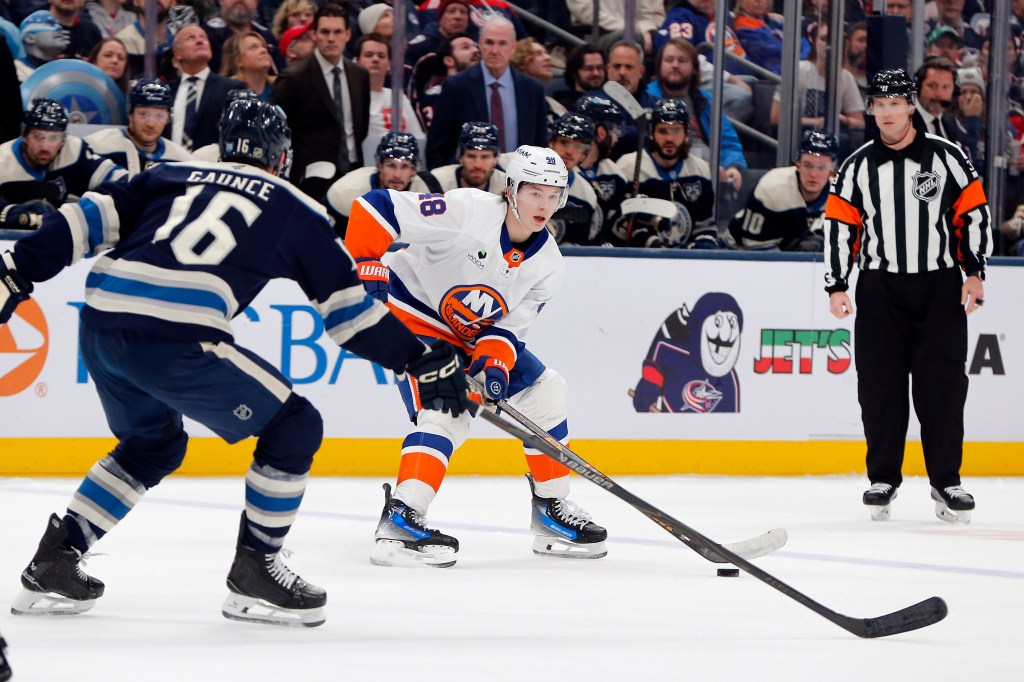 New York Islanders defenseman Matthew Schaefer (48) looks to pass as Columbus Blue Jackets center Brendan Gaunce (16) defends.