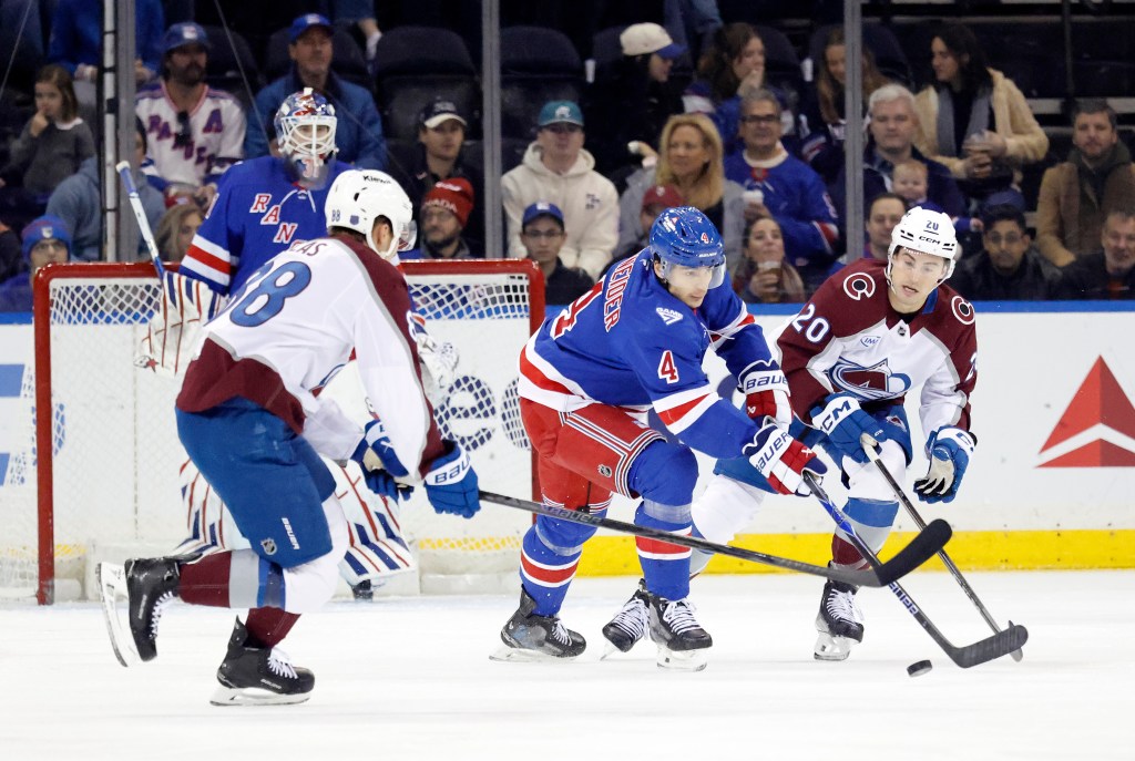 New York Rangers defenseman Braden Schneider (4) and Colorado Avalanche players Martin Necas (88) and Ross Colton (20) chase the puck in an ice hockey game.